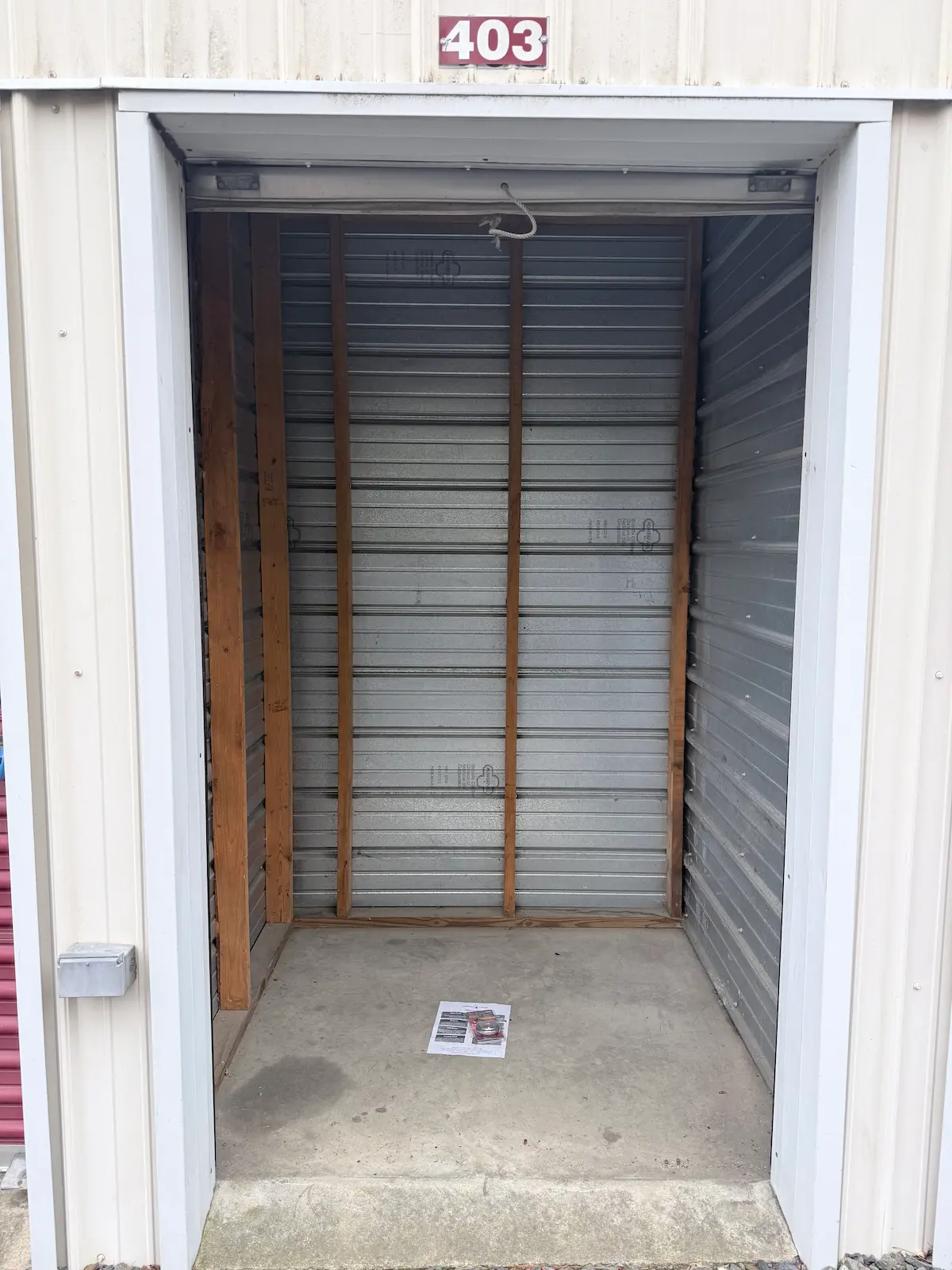 Interior of a 5x5 residential storage unit in Scranton with wooden shelving frame and horizontal metal storage slats, concrete floor, and clear space for personal items